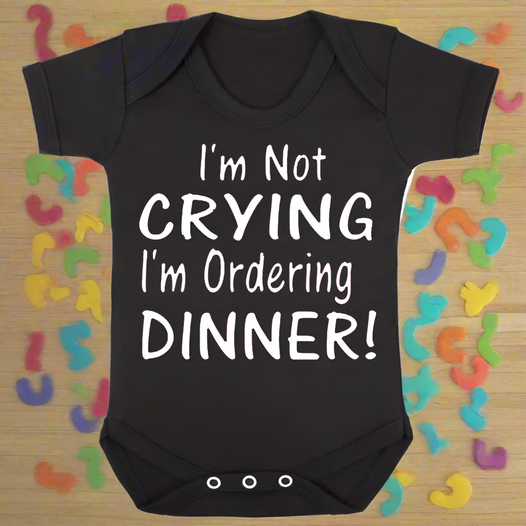 Black baby onesie with white text 'I'm Not Crying I'm Ordering Dinner!' on a white background