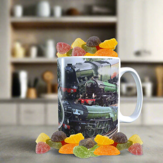 Mug with a train design filled with colorful gummy bears on a white background