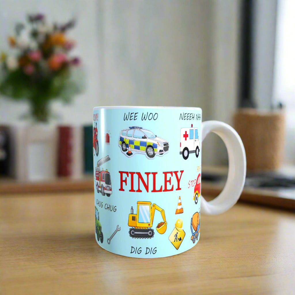 Children's mug with vehicle illustrations and the name 'FINLEY' on a light blue background.
