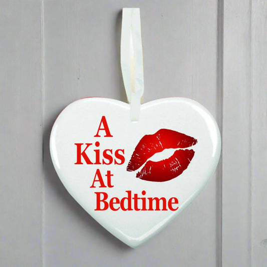 Heart-shaped white ornament with red lips and text 'A Kiss At Bedtime' on a white background