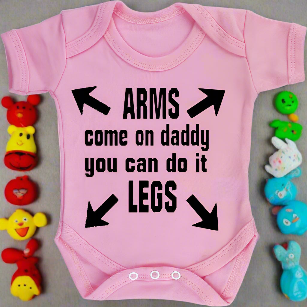 Pink baby onesie with black text and arrows on a white background