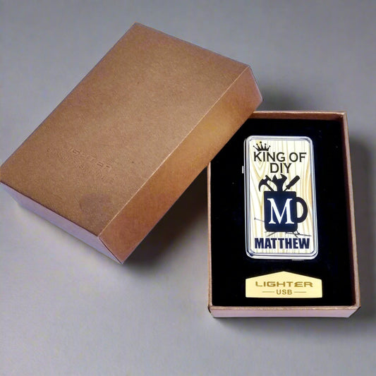 Lighter with 'King of DIY Matthew' design in a brown box on a white background