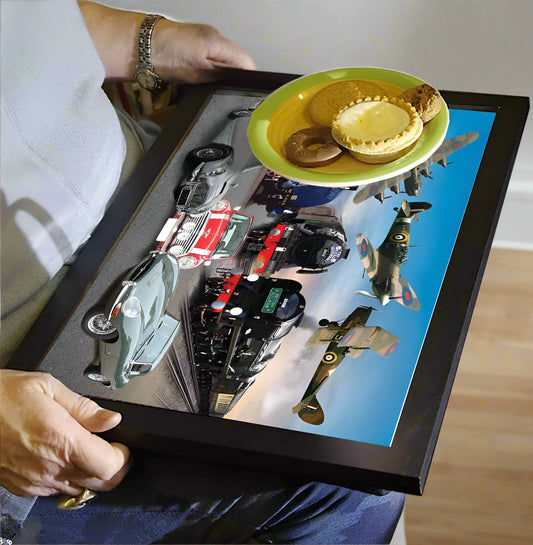 Person holding a tray with model cars and a cake on a digital display