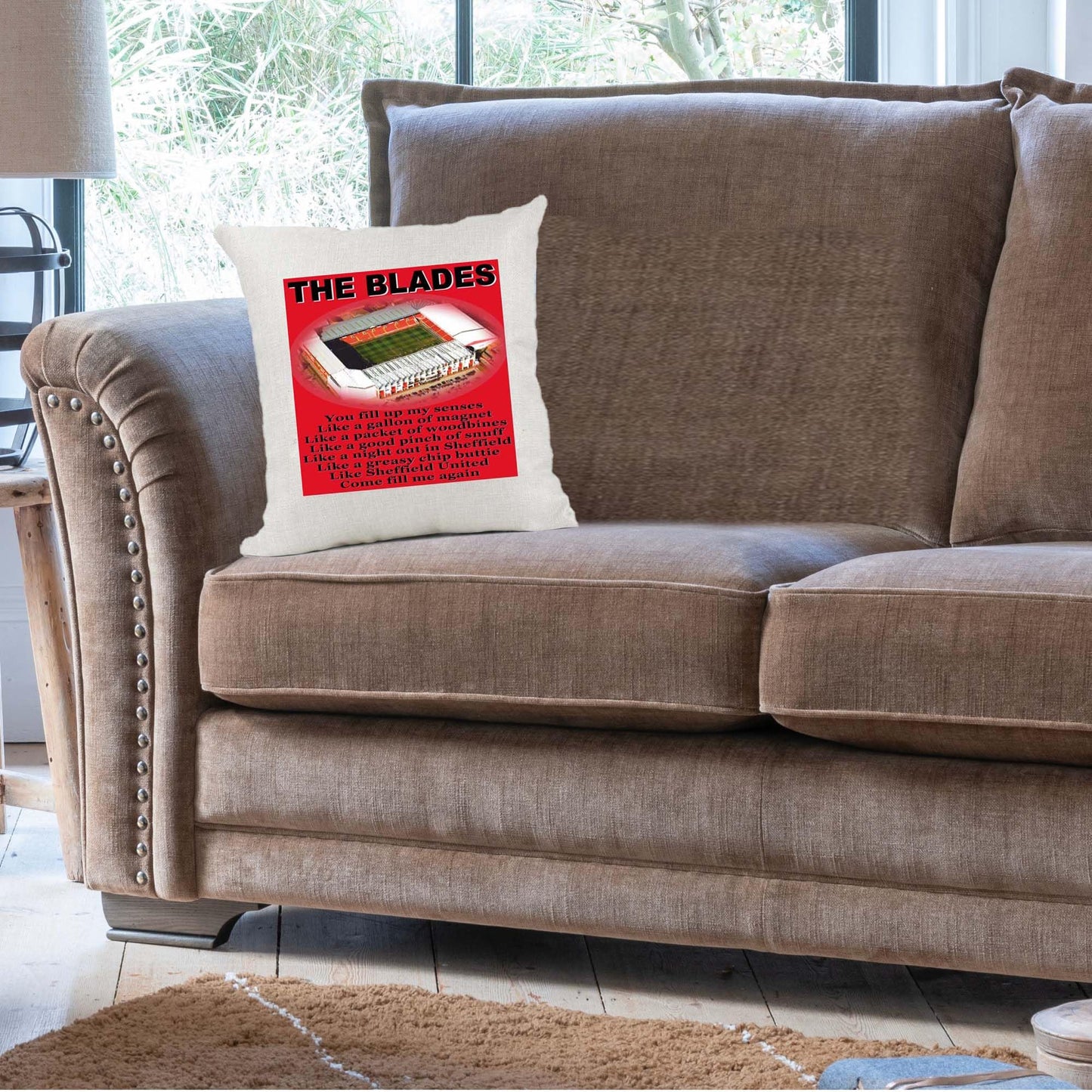Brown sofa with a pillow featuring 'The Blades' logo in a living room setting.