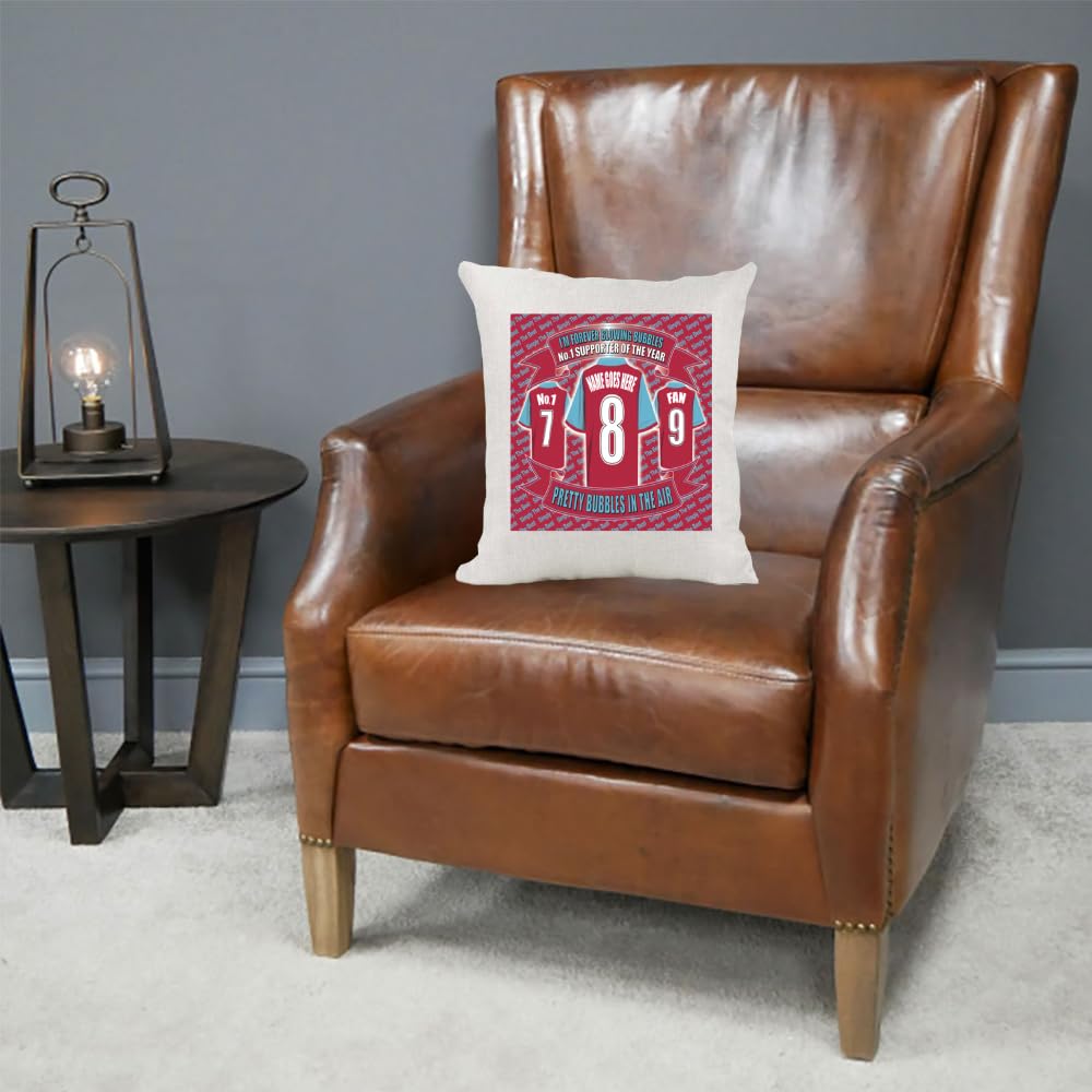 Brown leather armchair with a decorative pillow featuring sports jerseys on a gray wall background.
