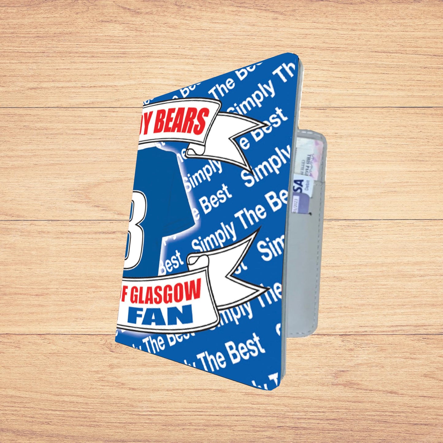 Blue and white product with 'Simply the Best' and 'F Glasgow Fan' text on a wooden surface