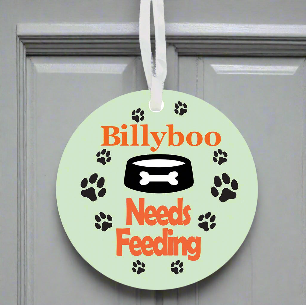 Round green tag with 'Billyboo Needs Feeding' text and dog-related graphics on a white background